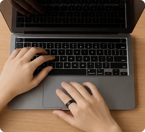 Wearing an Actxa ring while working at a laptop